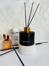 Load image into Gallery viewer, Grezns rudenīgs mājas aromāts ar kociņiem, rūgts grezns aromāts, mājas smaržas ar melniem kociņiem, melnā matētā pudelē ar zelta vāciņu, Ilze Ērgle Vanaga, I.ĒV
